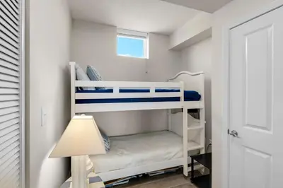 a small bedroom with two bunk beds and a lamp at Aqua 0411 in Panama City Beach