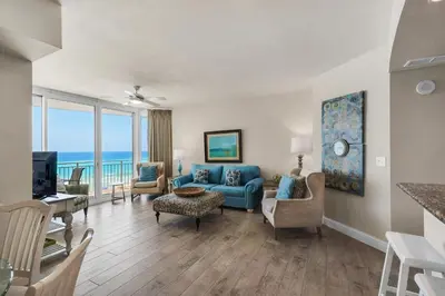a living room with a blue couch and chairs at Aqua 0411 in Panama City Beach