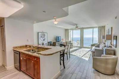 a kitchen and living room with a view of the ocean at Aqua 1905 in Panama City Beach
