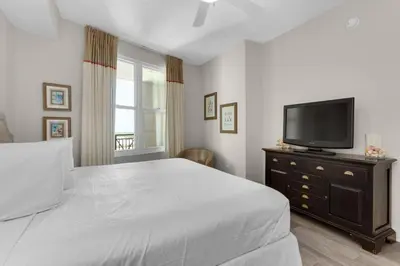 a bedroom with a bed and a flat screen tv at Aqua 1905 in Panama City Beach