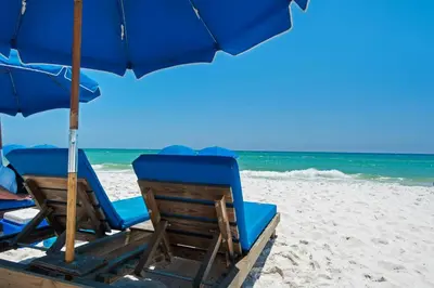 two chairs and an umbrella on a beach at Aqua 1905 in Panama City Beach