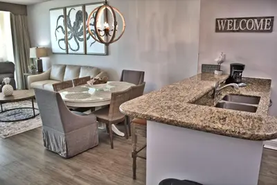 a kitchen and living room with a sink and a table at Aqua 0504 in Panama City Beach