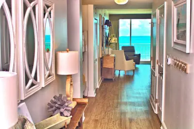 a hallway with a living room with a view of the ocean at Aqua 0504 in Panama City Beach