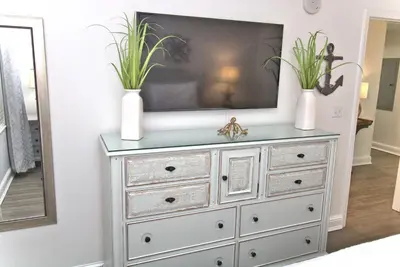 a television on a dresser with two plants on it at Aqua 0504 in Panama City Beach