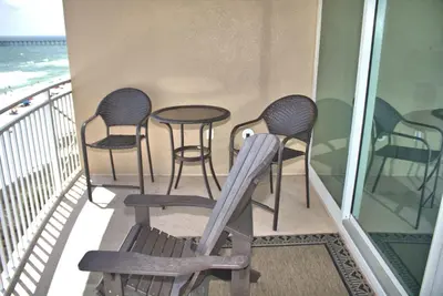 a balcony with four chairs and a table on it at Aqua 0504 in Panama City Beach