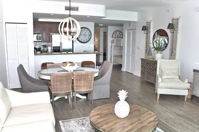a living room and kitchen with a table and chairs at Aqua 0504 in Panama City Beach