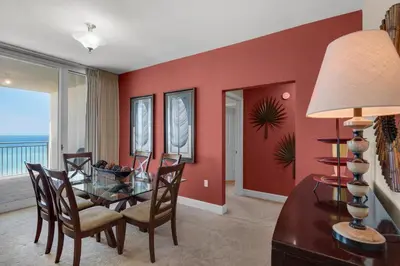 a dining room with a glass table and chairs at Aqua 0602 in Panama City Beach
