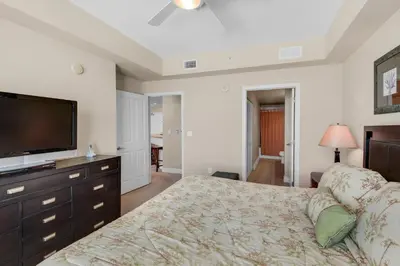 a bedroom with a bed and a flat screen tv at Aqua 0602 in Panama City Beach