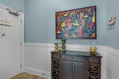a painting hanging on a wall above a wooden cabinet at Aqua 0709 in Panama City Beach