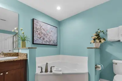 a bathroom with blue walls and a white tub at Aqua 0709 in Panama City Beach