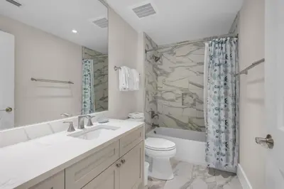 a white bathroom with a sink and a toilet at Aqua 1802 in Panama City Beach