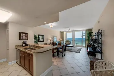 a kitchen and living room with a view of the ocean at Aqua 1105 in Panama City Beach