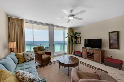 a living room with a blue couch and a television at Aqua 1105 in Panama City Beach