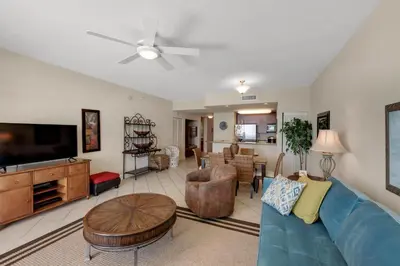 a living room with a blue couch and a tv at Aqua 1105 in Panama City Beach