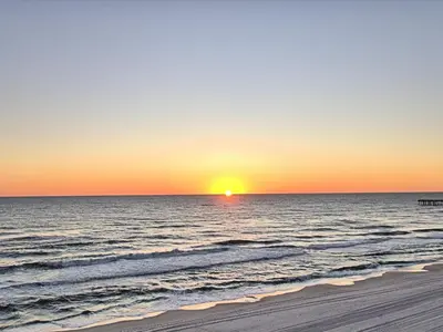 a sunset over the ocean with a sandy beach at Aqua 1609 in Panama City Beach