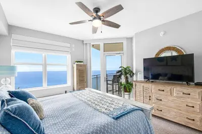 a bedroom with a bed and a flat screen tv at Aqua 1609 in Panama City Beach