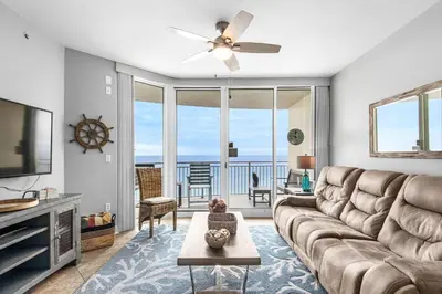 a living room with a couch and a flat screen tv at Aqua 1609 in Panama City Beach