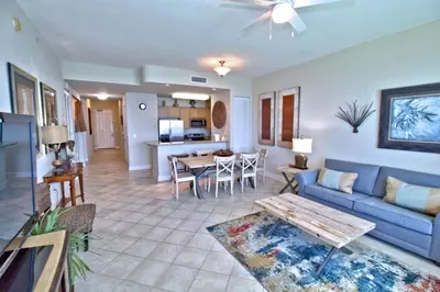 a living room with a blue couch and a table at Aqua 2305 in Panama City Beach