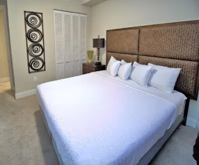 a bedroom with a large bed with white sheets and pillows at Aqua 2305 in Panama City Beach