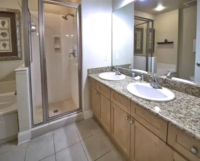 a bathroom with two sinks and a shower at Aqua 2305 in Panama City Beach