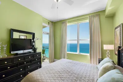 a bedroom with a bed with a television and a window at Aqua 2307 in Panama City Beach