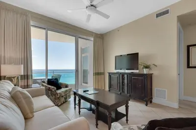 a living room with a couch and a tv at Aqua 2307 in Panama City Beach