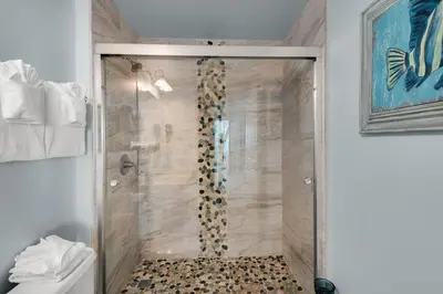 a shower with a glass door in a bathroom at Aqua 1402 in Panama City Beach