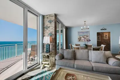 a living room with a couch and a balcony at Aqua 1402 in Panama City Beach