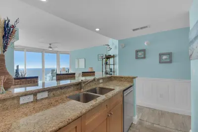 a kitchen with a sink and an ocean view at Aqua 1711 in Panama City Beach