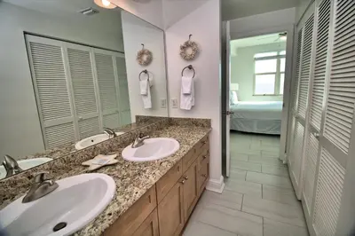 a bathroom with two sinks and a large mirror at Aqua 1502 in Panama City Beach