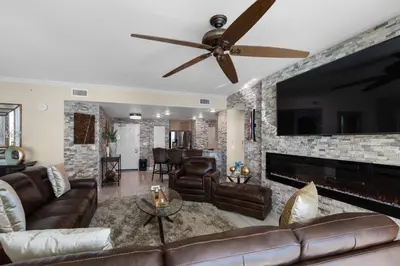 a living room with a couch and a ceiling fan at Aqua 1602 in Panama City Beach