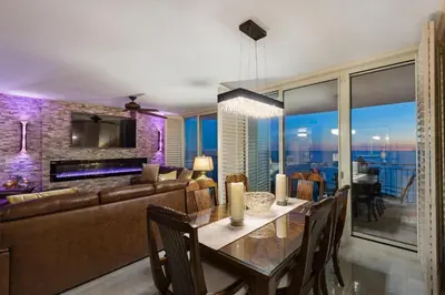 a dining room and living room with a couch and a table at Aqua 1602 in Panama City Beach