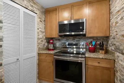 a kitchen with a stove and a microwave at Aqua 1602 in Panama City Beach