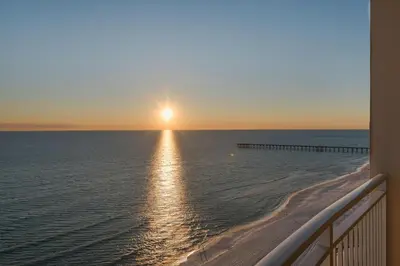 a view of the ocean at sunset from the balcony of a condo at Aqua 1602 in Panama City Beach
