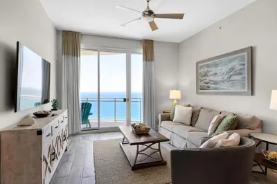 a living room with a couch and a large window at Aqua 2308 in Panama City Beach