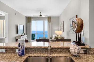 a kitchen and living room with a view of the ocean at Aqua 2308 in Panama City Beach