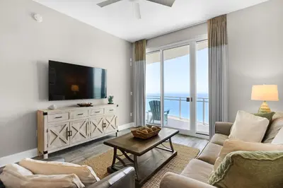 a living room with a tv and a couch and a table at Aqua 2308 in Panama City Beach