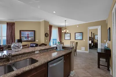 a kitchen with a sink and a living room at Aqua 2201 in Panama City Beach