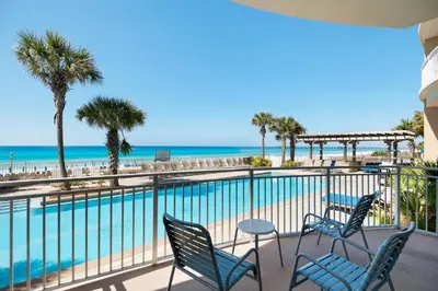 a balcony with chairs and a pool and the beach at Aqua 2201 in Panama City Beach