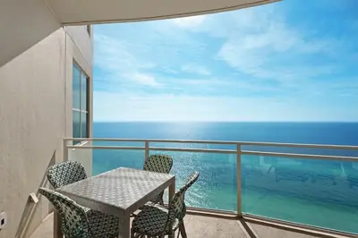 a balcony with a table and chairs and the ocean at Aqua 2201 in Panama City Beach