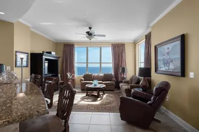 a living room filled with furniture and a table at Aqua 2201 in Panama City Beach