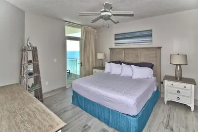 a bedroom with a bed with a ceiling fan at Aqua 2111 in Panama City Beach