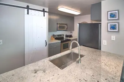 a kitchen with a sink and a refrigerator at Aqua 2111 in Panama City Beach