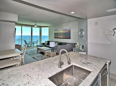 a kitchen and living room with a view of the ocean at Aqua 2111 in Panama City Beach