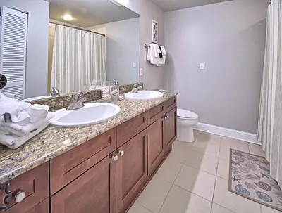 a bathroom with two sinks and a toilet at Aqua 1507 in Panama City Beach