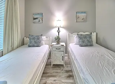 a bedroom with two beds and a table with a lamp at Aqua 1507 in Panama City Beach