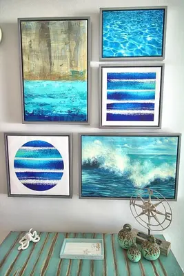 a group of paintings on a wall with a table at Aqua 0506 in Panama City Beach