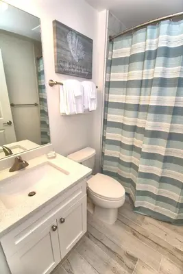 a bathroom with a sink and a toilet and a shower at Aqua 0506 in Panama City Beach