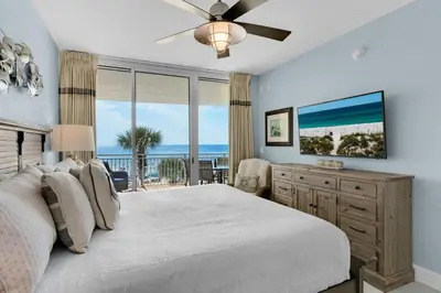 a bedroom with a bed and a view of the ocean at Aqua 0208 in Panama City Beach