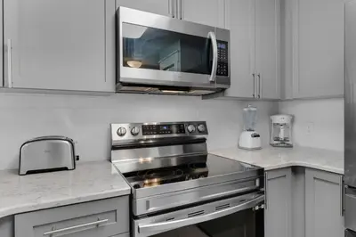 a kitchen with a stainless steel stove and a microwave at Aqua 0208 in Panama City Beach